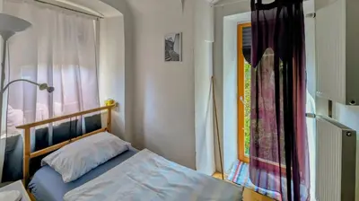 a small bedroom with a bed and a window at Very old house Ptice in Ptice