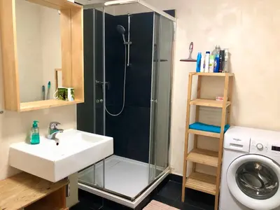 a bathroom with a shower and a sink and a washing machine at Prague apartment in Centre city in Prague