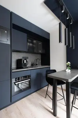 a kitchen with blue cabinets and a table with chairs at Smarty Choice Living with Netflix - Kubanske namesti in Prague