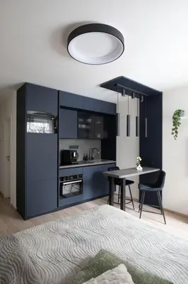 a kitchen with blue cabinets and a table with chairs at Smarty Choice Living with Netflix - Kubanske namesti in Prague