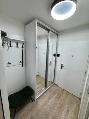 a room with a mirror and a green chair at Smarty Choice Living with Netflix - Kubanske namesti in Prague