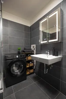 a bathroom with a washing machine and a sink at Smarty Choice Living with Netflix - Kubanske namesti in Prague