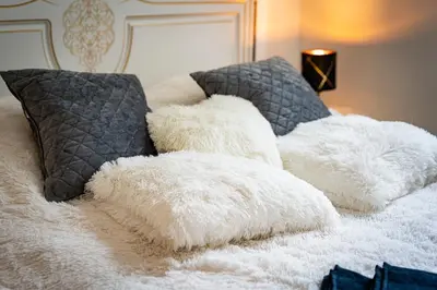 a pile of white pillows on top of a bed at Bohemian Emperors Residence in Prague