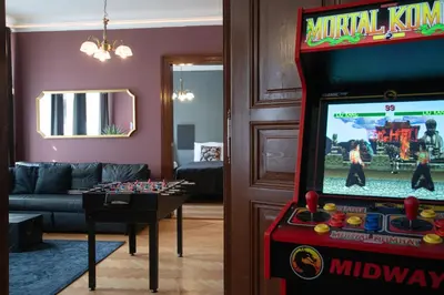 a living room with a video game console and a game table at Spacious Apartment Xbox, Cinema & Foosball in Prague in Prague