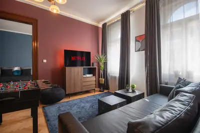 a living room with a couch and a tv at Spacious Apartment Xbox, Cinema & Foosball in Prague in Prague