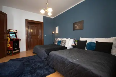 a bedroom with two beds and a blue wall at Spacious Apartment Xbox, Cinema & Foosball in Prague in Prague