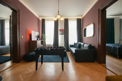 a living room with a table and a couch at Spacious Apartment Xbox, Cinema & Foosball in Prague in Prague