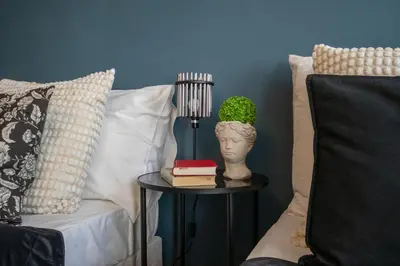 a side table with a statue of a head and a lamp at Spacious Apartment Xbox, Cinema & Foosball in Prague in Prague