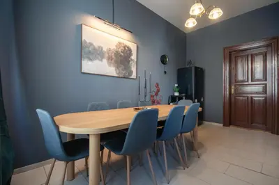 a dining room with a wooden table and blue chairs at Spacious Apartment Xbox, Cinema & Foosball in Prague in Prague