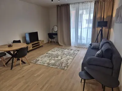 a living room with a blue couch and a table at Smichov Luxury Apartments Residence Madeleine in Prague