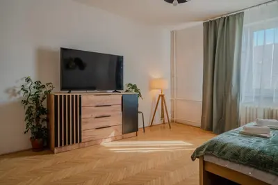 a living room with a flat screen tv on a dresser at Spacious residential apt with balcony by TV tower in Prague