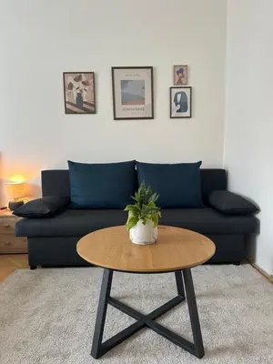 a living room with a couch and a coffee table at Spacious residential apt with balcony by TV tower in Prague