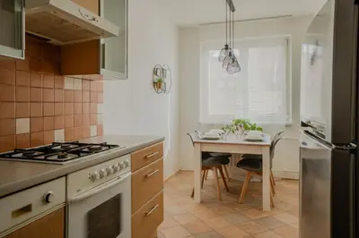a kitchen with a table and a stove top oven at Spacious residential apt with balcony by TV tower in Prague