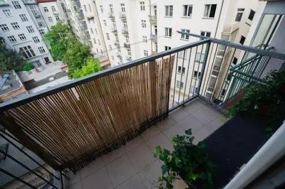 a balcony of a building with a fence and plants at Spacious residential apt with balcony by TV tower in Prague