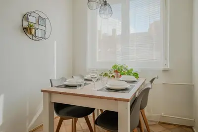 a dining room with a wooden table and chairs at Spacious residential apt with balcony by TV tower in Prague