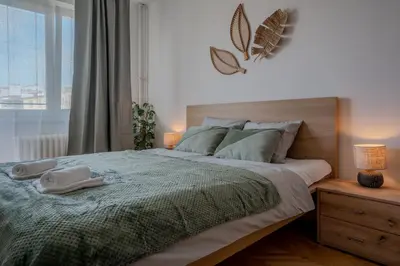 a bedroom with a large bed with two towels on it at Spacious residential apt with balcony by TV tower in Prague