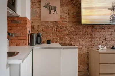a kitchen with white cabinets and a brick wall at Apartment Dalimilova in Prague