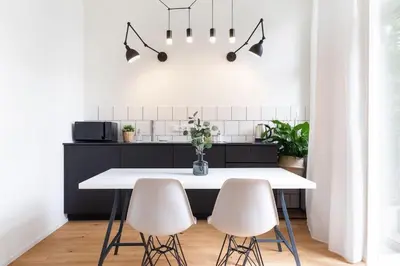 a kitchen with a white table and two white chairs at Apartment Dalimilova in Prague