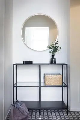 a mirror on a wall above a black shelf with a plant at Apartment Dalimilova in Prague