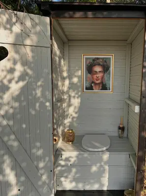 a toilet in a shed with a picture of a woman at Ostrov klidu - posed - sauna