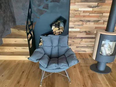 a living room with a chair next to a fireplace at Hrdlička Slapy Chalot in Buš