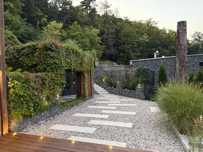 a walkway in a garden with a stone wall at Hrdlička Slapy Chalot in Buš