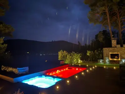 a pool with lights in a backyard at night at Hrdlička Slapy Chalot in Buš