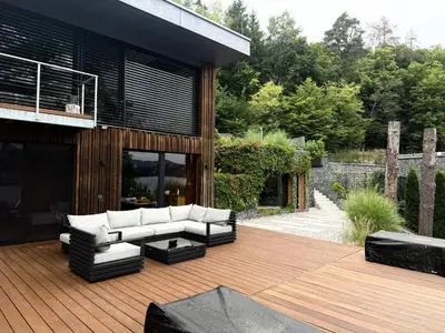 a patio with a couch and chairs on a wooden deck at Hrdlička Slapy Chalot in Buš