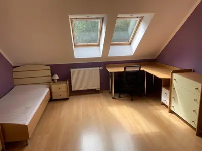a bedroom with a bed and a desk and two windows at Rodinný dům Divišov u Benešova, Na Spravedlnosti 276 in Vlašim