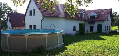 a house with a large swimming pool in front of it at Chalupa u Kahounů in Popovice