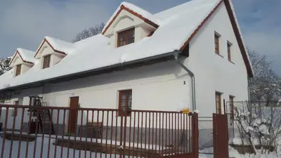 a white house with snow on the roof at Chalupa u Kahounů in Popovice