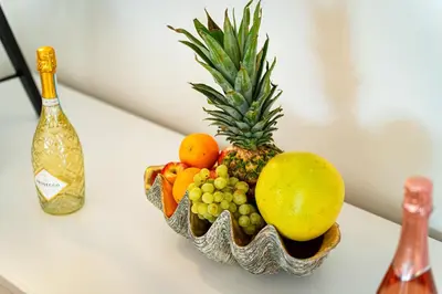 a bowl of fruit on a table with a bottle of wine at Bright Bohemian River in Prague