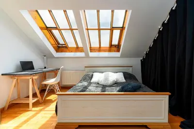 a bedroom with a bed and a desk with a laptop at Bright Bohemian River in Prague