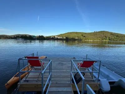 two red chairs sitting on a dock on a lake at Slapy One&Only in Buš