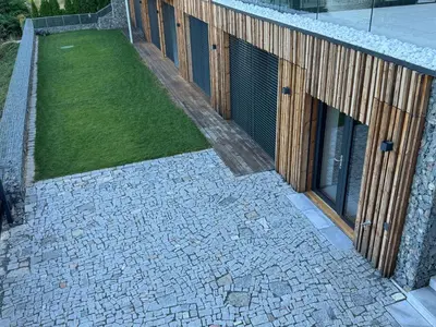 a building with a grass yard next to a building at Slapy One&Only in Buš