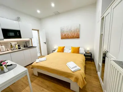 a bedroom with a large bed with orange pillows at Krakovka Suites in Prague
