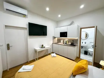 a white room with a large yellow rug in a room at Krakovka Suites in Prague