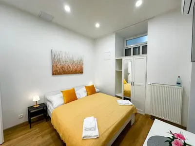 a bedroom with a yellow bed in a room at Krakovka Suites in Prague