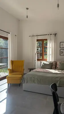 a bedroom with a bed and a yellow chair at Home apartment Konopiště