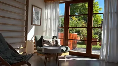 a living room with a chair and a table and a window at Home apartment Konopiště