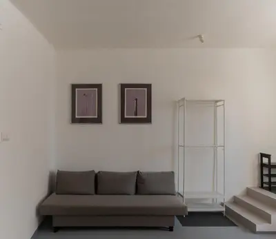 a living room with a couch and two pictures on the wall at New spacious apartment for 6 people, direct entrance in Prague