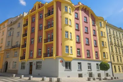 a yellow and pink building on a street at New spacious apartment for 6 people, direct entrance in Prague