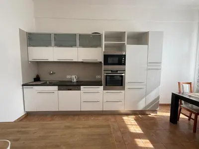 a white kitchen with white cabinets and a table at CUBE Apt in Prague center in Prague