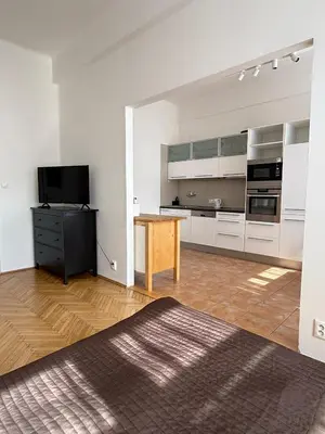 a kitchen with white cabinets and a wooden table at CUBE Apt in Prague center in Prague
