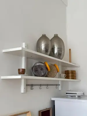 a kitchen with white shelves with vases on them at CUBE Apt in Prague center in Prague