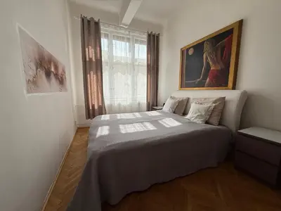 a bedroom with a bed and a painting on the wall at CUBE Apt in Prague center in Prague