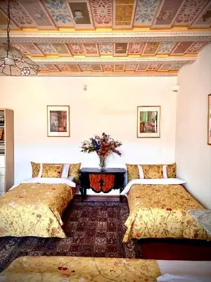a bedroom with two beds and a vase of flowers at Villa Riviera in Prague
