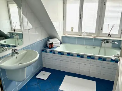 a blue and white bathroom with a tub and a sink at Villa Riviera in Prague