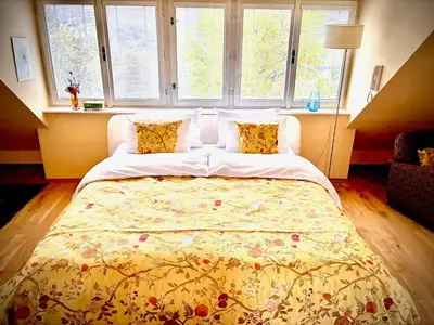 a bedroom with a large bed with a yellow blanket at Villa Riviera in Prague