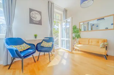 a living room with two blue chairs and a couch at De Luxe Suite with balcony in Angelo Residence by Rentez in Prague
